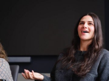 Madison Square Garden employee smiling and answering questions, sitting at a conference table.